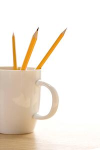 Three pencils in a coffee cup with pointed ends up