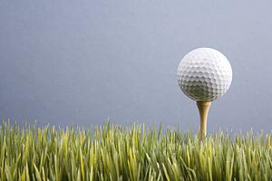 Studio shot of golf ball resting on tee in grass