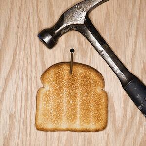 Slice of nailed to wood with hammer