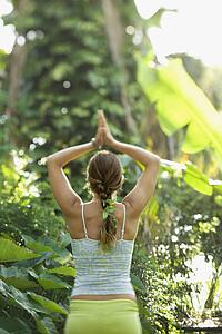 Woman holding arms overhead in yoga position