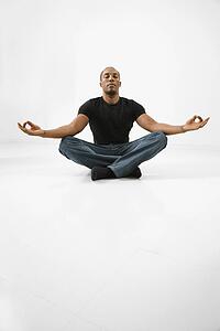 Young male adult sitting and meditating