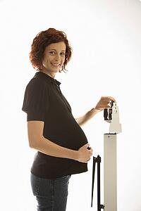 Pregnant woman standing on scale 