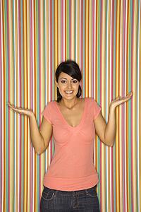 Woman shrugging on striped background