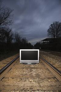 Flat panel television set on railroad tracks at night