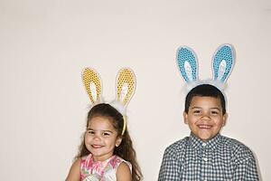 Boy and girl wearing bunny ears, smiling