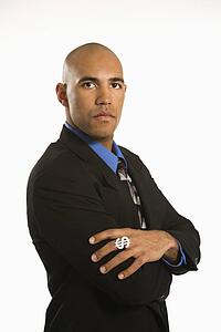 African American man in suit wearing ring with money sign.