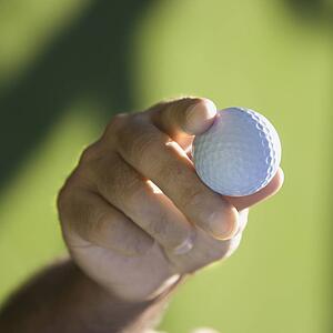 Mid adult male hand holding golf ball
