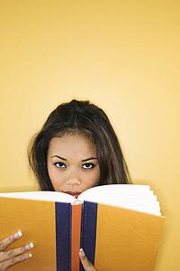 Woman peering over book