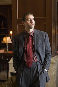 Businessman looking to side with hands in pockets