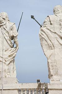Back view of Roman statues with blue sky in Rome, Italy.