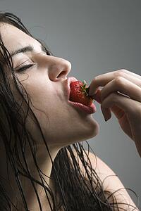 Woman biting a strawberry