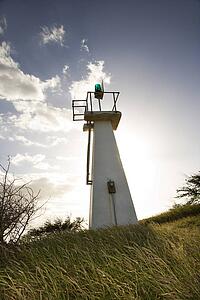 Lighthouse in grassy field 