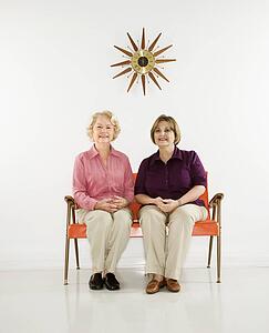 Caucasian middle aged woman and senior woman sitting together.