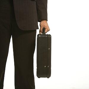 African American businessman in suit holding briefcase.