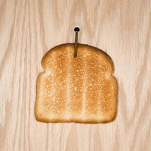 Slice of toast nailed to wood