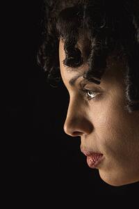 Profile of mid adult Hispanic woman with curly hair.