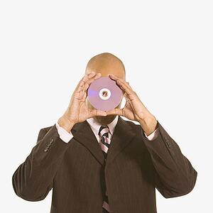 Man holding compact disc over his face