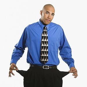 African American man in suit pulling out empty pockets.