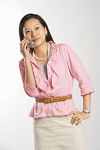 Female with hand on hip smiling and talking on cell phone