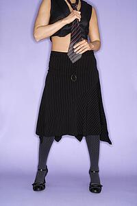 Body portrait of woman wearing necktie standing against purple background.