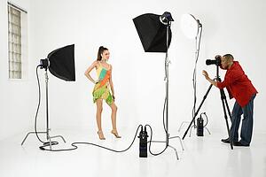 Model being photographed in studio by a male photographer