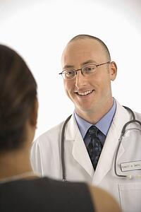Caucasian mid adult male physician talking with Indian woman patient.