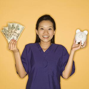 Doctor holding piggy bank in one hand and cash in the other 