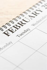 Close up of spiral bound calendar displaying month of February