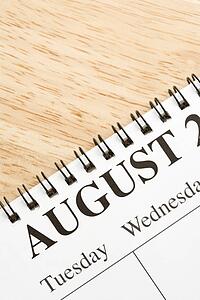 Close up of spiral bound calendar displaying month of August