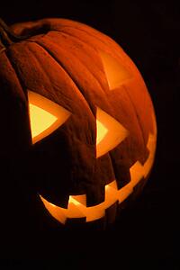 Carved Halloween pumpkin glowing in the dark.
