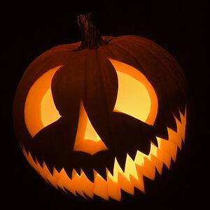 Carved Halloween pumpkin glowing in the dark.