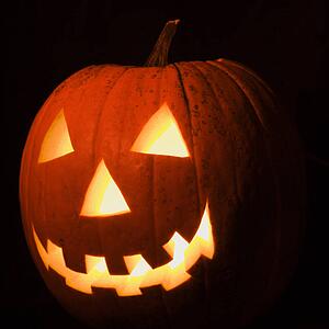 Carved Halloween pumpkin glowing in the dark.