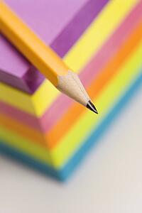 Close up of sharp pencil on stack of colorful sticky notes