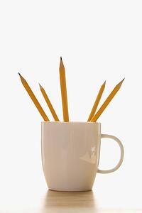 Five pencils in a coffee cup with pointed ends up