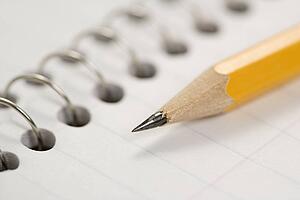 Close up of pencil on top of spiral bound notebook