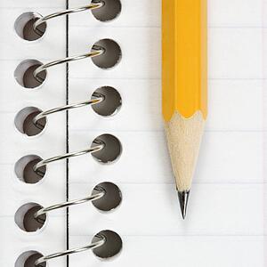 Close up of pencil on top of spiral bound notebook