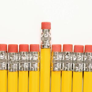 Even row of eraser ends of pencils with one raised higher than the rest.