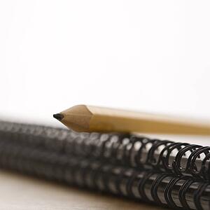 Close up of pencil on top of spiral bound notebook