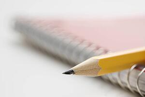 Close up of pencil on top of spiral bound notebook