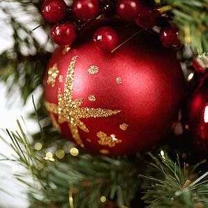 Close up of red ornament and berries on Christmas wreath.