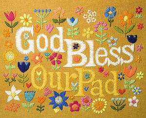 Vintage needlepoint wall hanging of colorful flowers surrounding the phrase God Bless Our Pad