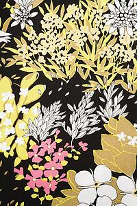 Close-up of vintage fabric with pattern of pink and golden flowers and leaves on polyester