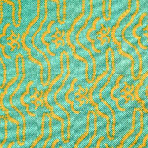 Close-up of turquoise vintage fabric with repetitive yellow designs printed on polyester