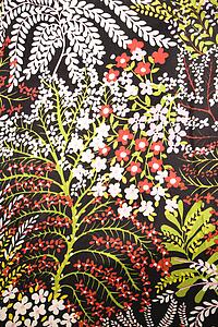 Close-up of vintage fabric with red green and white flowers printed on polyester