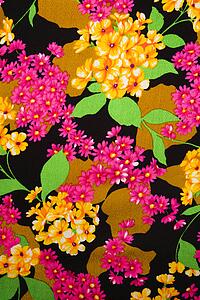 Close-up of vintage fabric with vibrant pink and yellow flowers printed on polyester