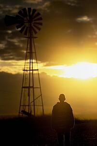Man standing by a windmill