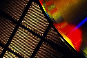 Close-up of a microchip wafer and a compact disk