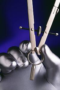 Silver hand holding drafting compass