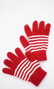 A pair of red and white gloves laying on the snow