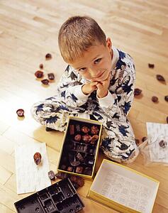 Boy into box of chocolates